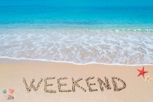 "weekend" written in the sand on a tropical beach