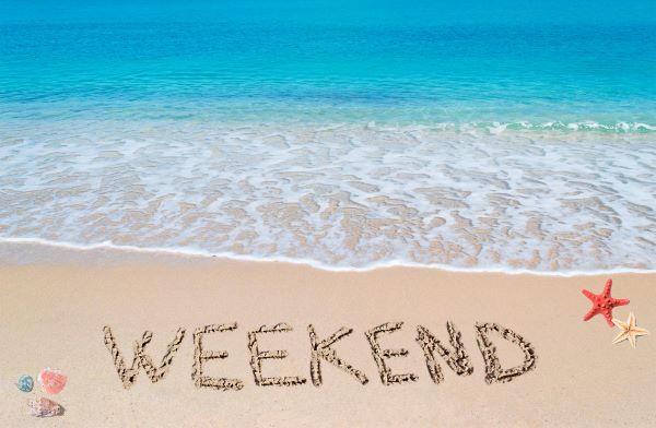 "weekend" written in the sand on a tropical beach