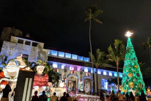 Shaka Santa and Tūtū Mele with the Honolulu Hale Christmas Tree
