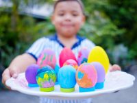 young boy with a platter of colorful easter eggs