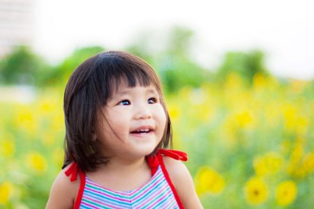 smiling toddler girl in a sunflower field