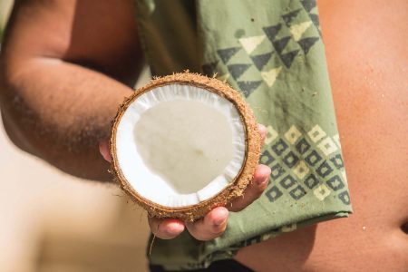 Man holding a fresh coconut half