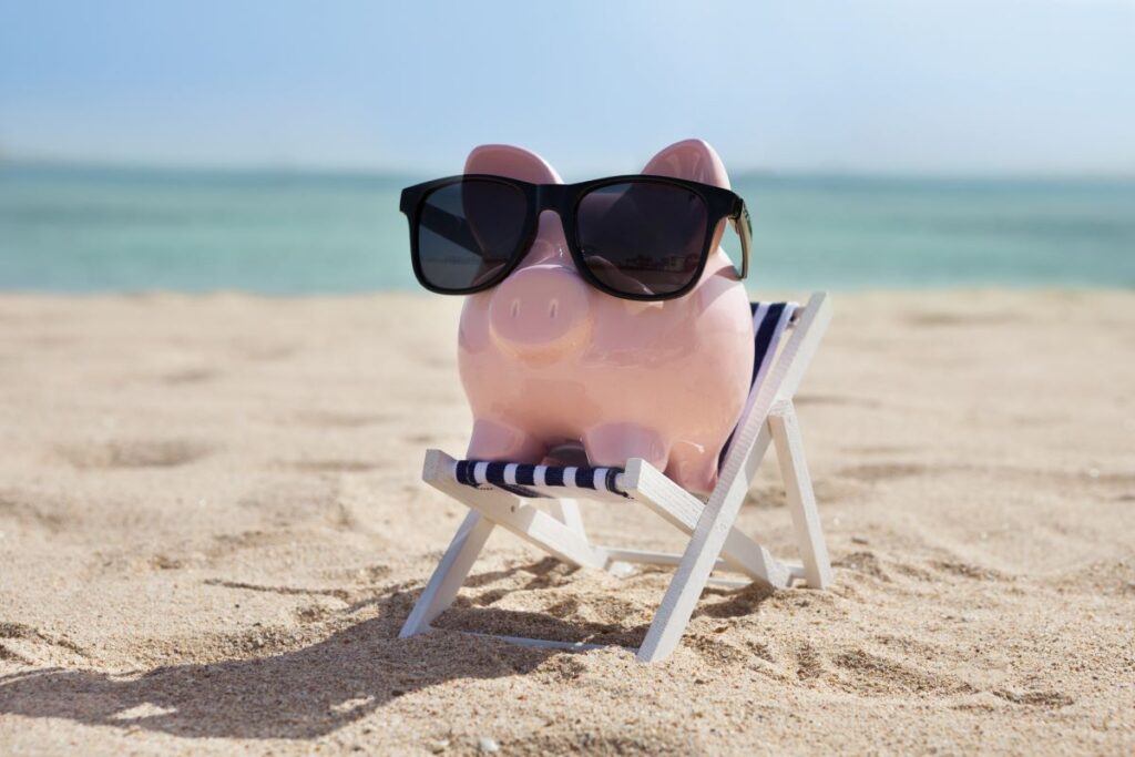 piggy bank relaxing in a chair at the beach