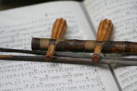 top of Chinese erhu fiddle music instrument laying on sheet music