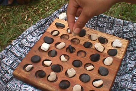 Konane wood and stone game board