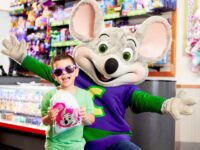 Young boy with mouse character at Chuck E. Cheese