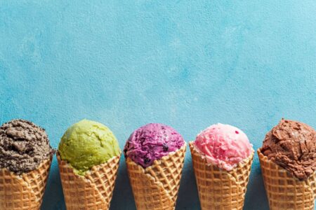 A row of ice cream flavors in waffle cones