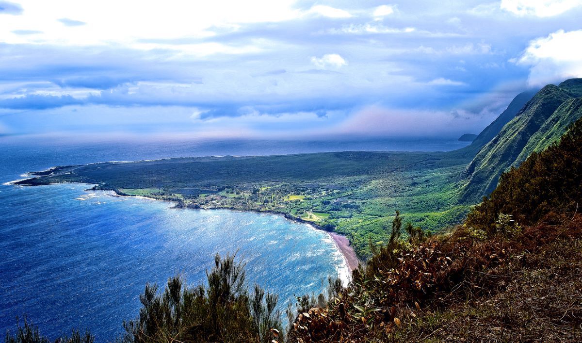 Molokai’s Kalaupapa Peninsula - a remote flatland at the base of cliffs rising to 2,000 feet (600m). Photo by John Richard Stephen.